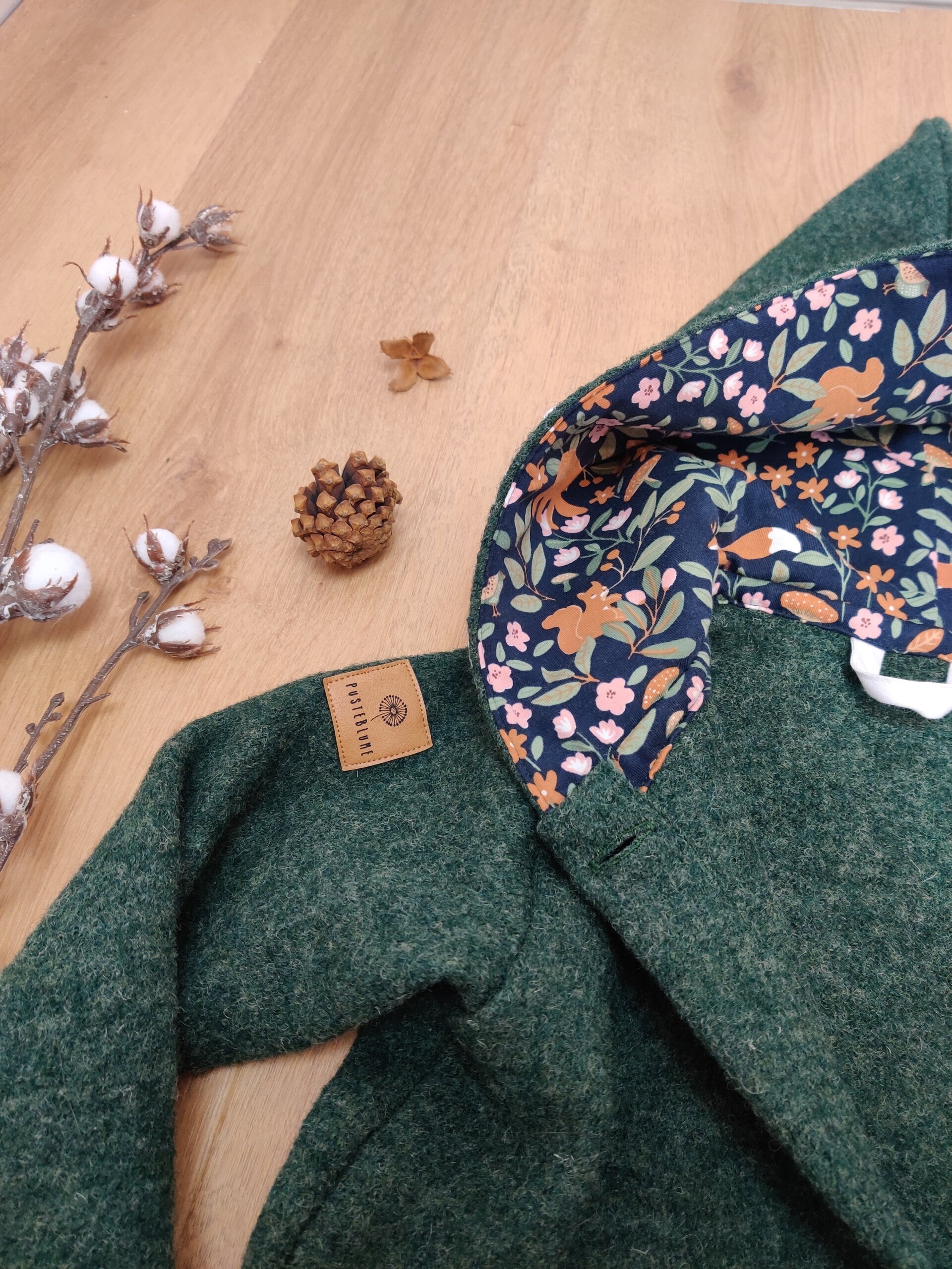 Walkmantel in tannengrün mit Zipfelkapuze teilweise gefüttert und mit Knöpfen und Spitze